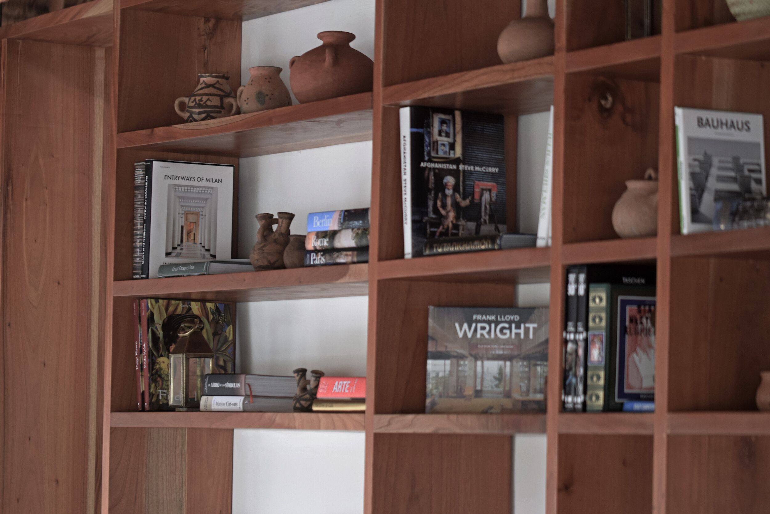 Une bibliothèque en bois contenant divers livres et objets décoratifs.