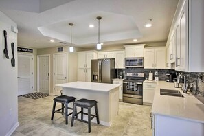 Enjoy cooking in this well-equipped kitchen with a central island, bar stools, and ample counter space.