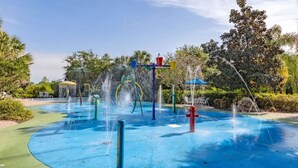 A water play area with multiple fountains and a blue rubberized surface. - Perfect Disney/Golf Vacation Condo (Davenport)