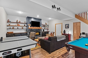 Télévision, cheminée, table de tennis de table, livres