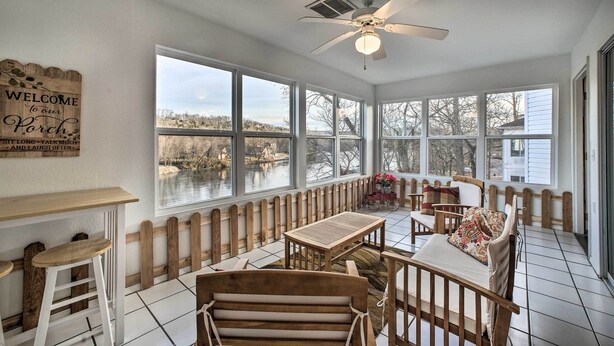 A sunroom with large windows, a ceiling fan, and a wooden bench. - Lakefront Branson Getaway Near Marina & Fishing! (Branson)