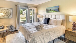 Una camera da letto con un letto grande, due abat-jour, una testiera e un quadro appeso al muro.