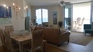 A dining area with a wooden table and chairs, a sofa, and a ceiling fan.