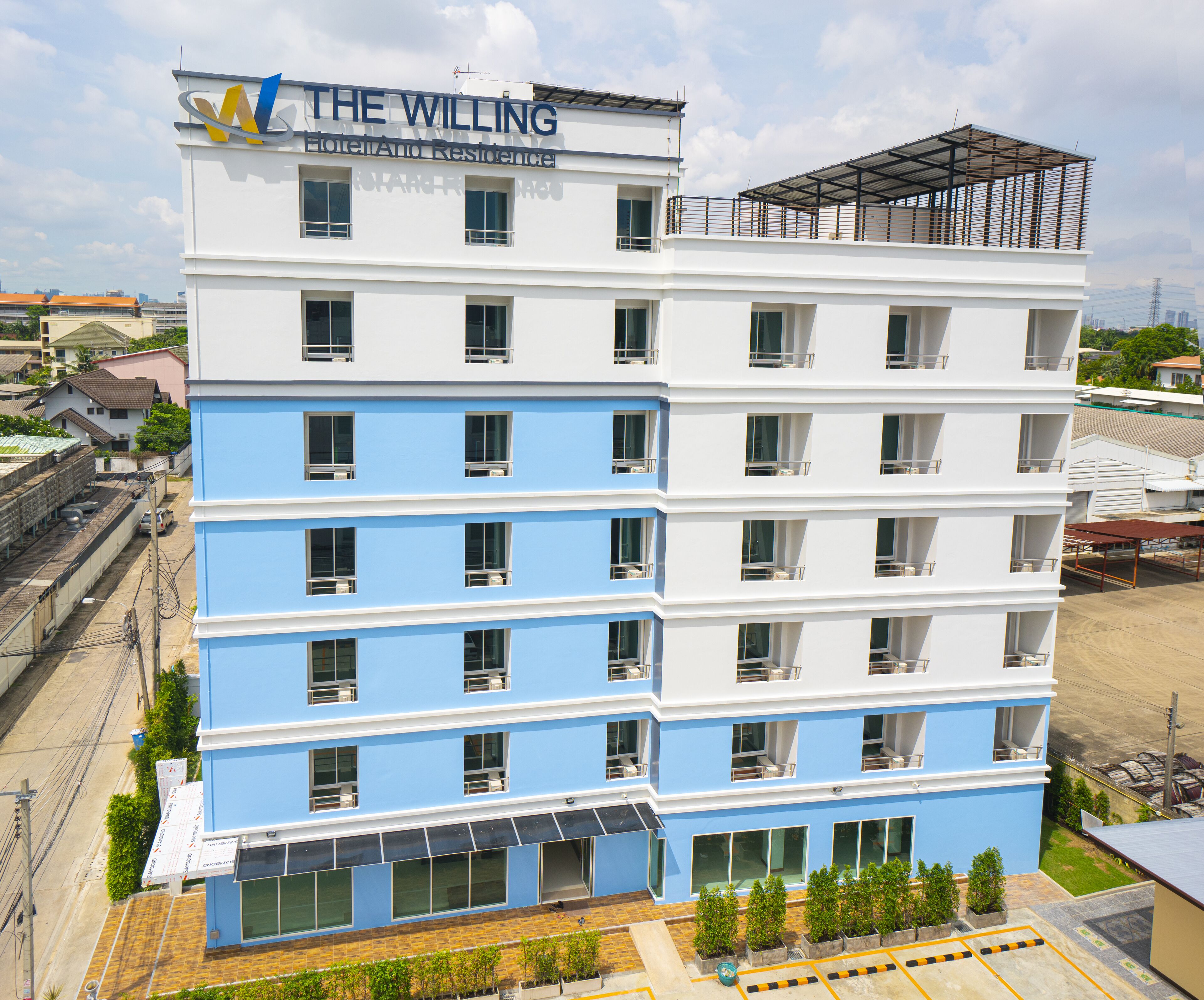 Un hotel de varios pisos con diseño moderno, con balcones en cada planta y una vista despejada del entorno.