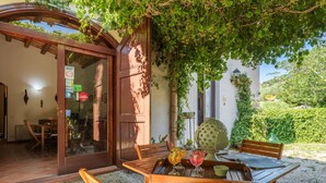 An outdoor dining area with wooden furniture and a table set with drinks. - Beautiful private villa for 14 people with WIFI, private pool, TV, terrace and pets allowed (Buseto Palizzolo)