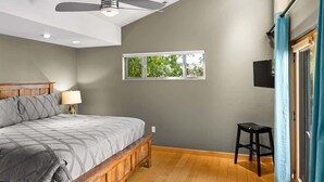A bedroom with a bed, a window, a ceiling fan, and a TV mounted on the wall. - Rooftop Deck, Sedona Views, Fenced Yard +Pets! (Sedona)
