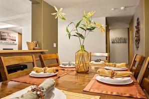Enjoy meals in this cozy dining area with a fireplace, wooden table, and comfortable seating for four.