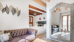 A spacious room with a leather sofa, a wooden table, and a large mirror. - VINTAGE PALMA PALACE (SUPERIOR 4) by Priority (Palma de Mallorca)