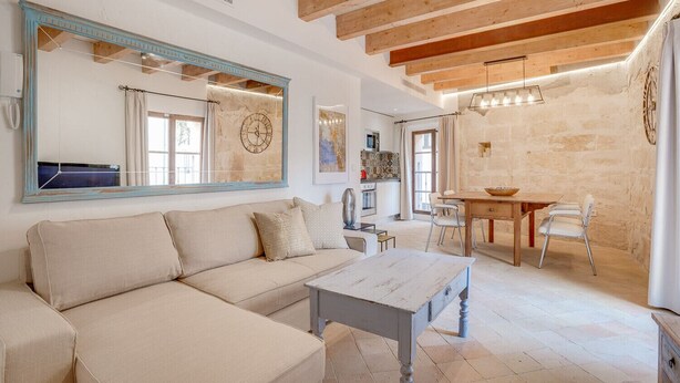A spacious living area with a sofa, a dining table, and a large mirror. - VINTAGE PALMA PALACE (SUPERIOR 4) by Priority (Palma de Mallorca)