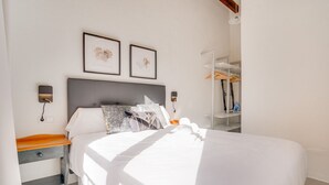 A neatly made bed with white linens, a grey headboard, and two framed pictures on the wall. - VINTAGE PALMA PALACE (SUPERIOR 5) by Priority (Palma de Mallorca)