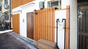 A building with a wooden fence, a bench, and a water meter. - Xiaoningge (Osaka)
