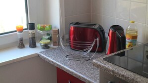 A kitchen with a toaster, a kettle, and a bottle of oil on the counter. - Apartment 1 - Apartment Rosenstadt (Forst (Lausitz))