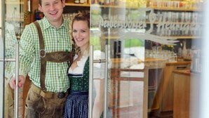 Un homme et une femme se tiennent devant un bar, devant une vitrine réfrigérée.