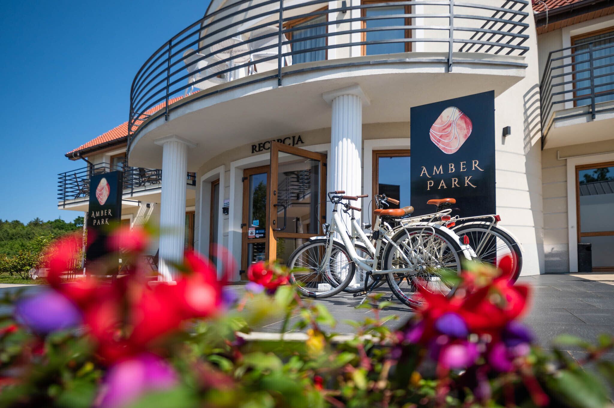A building with a sign reading "AMBER PARK" and a bicycle parked in front.