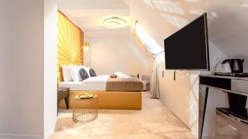 A modern hotel room with a bed, a television, a desk, and a small table.