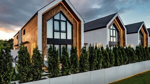 Un edificio residencial moderno con ventanas grandes y fachada de madera.