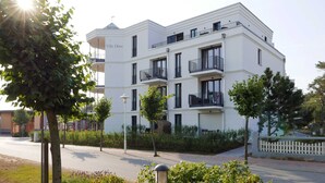 Un edificio de varios pisos con balcones, un letrero que dice "Villa Dune" y una calle en primer plano.