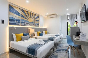 A hotel room with two beds, a desk, a chair, a TV, and a large abstract painting on the wall.