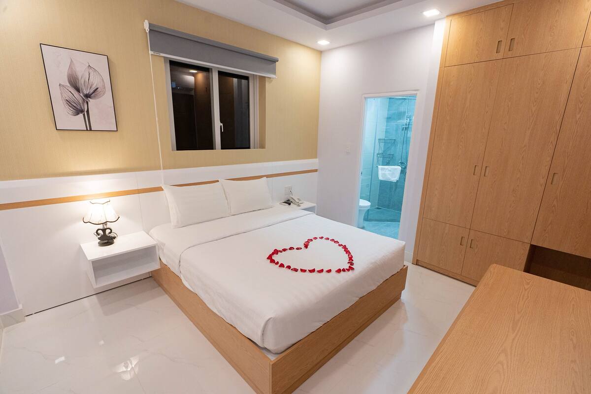 Un dormitorio moderno con cama, mesita de noche y armario de madera.