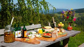 Ein Picknicktisch mit Speisen, Getränken und einem Blumenstrauß.