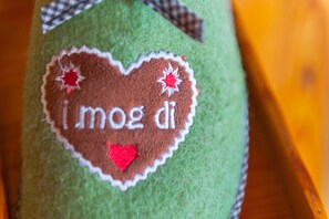 A close-up of a green felt object with a heart-shaped patch and the text 'i love you' embroidered on it. - Bionest III - Arche organic country house (Eberstein)