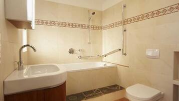 Een badkamer met een wastafel, bad en toilet.