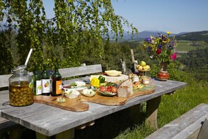 A picnic table with food, drinks, and a vase of flowers. - Bionest III - Arche organic country house (Eberstein)