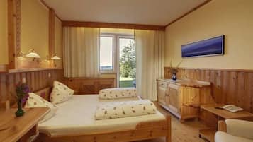 Um quarto de madeira com cama, mesa de cabeceira, luminária e janela com cortinas.
