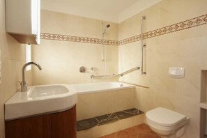 A bathroom with a sink, bathtub, and toilet. - Bionest II earth building apartment - Biolandhaus Arche (Eberstein)