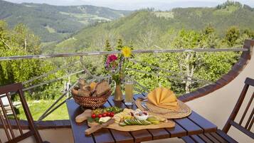 Ein Tisch mit verschiedenen Speisen und Blick auf eine Berglandschaft.