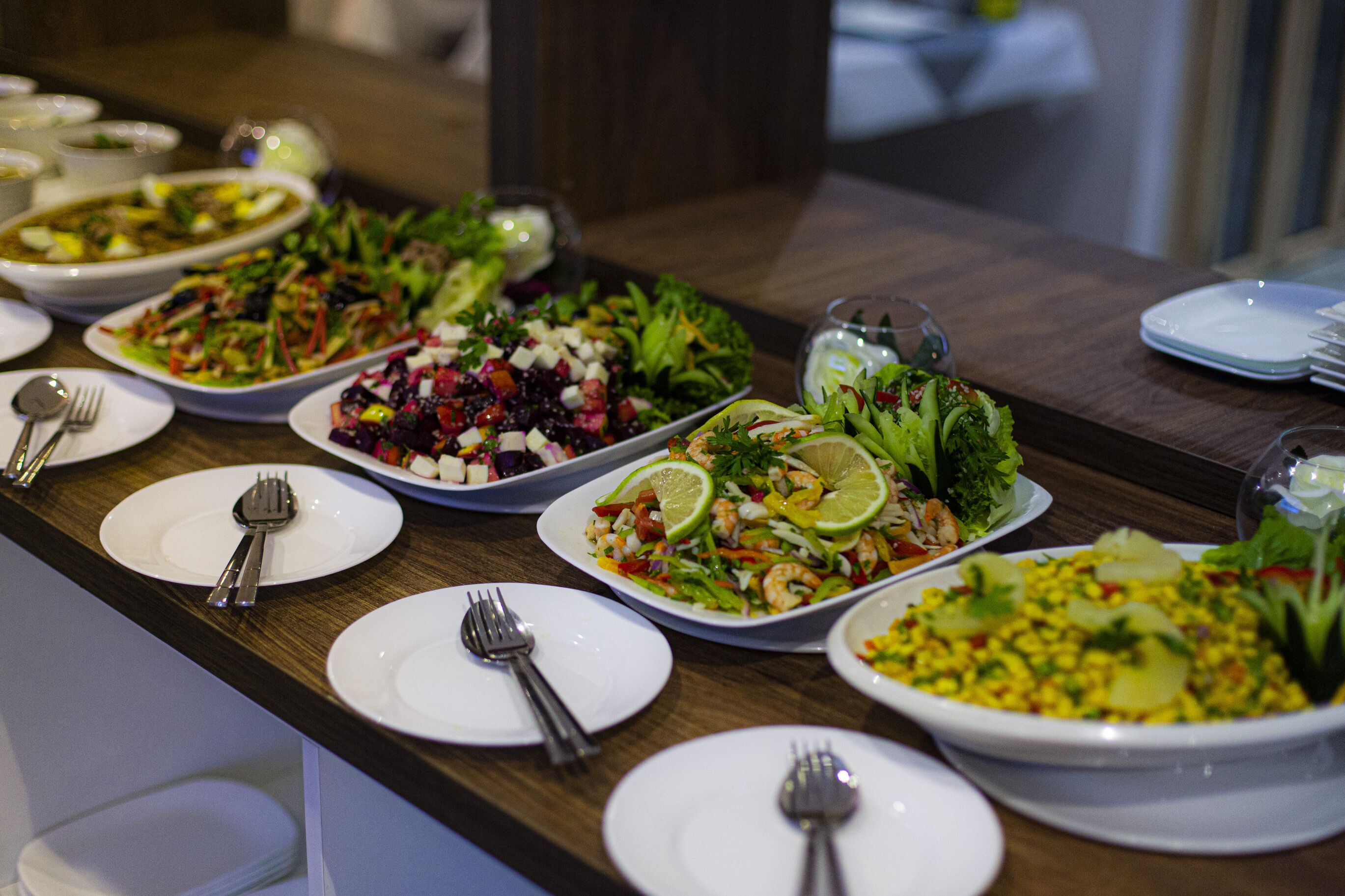 Uma mesa de buffet com diversos pratos e utensílios.