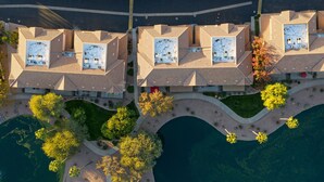 Vista aérea de una zona residencial con varias casas, un camino curvo y una masa de agua.
