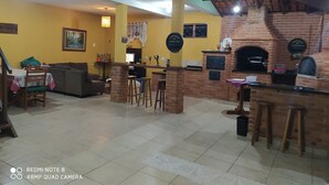 A spacious living area with a brick fireplace, a dining table with chairs, and a sofa. - Holiday Home in Atibaia  (Atibaia)