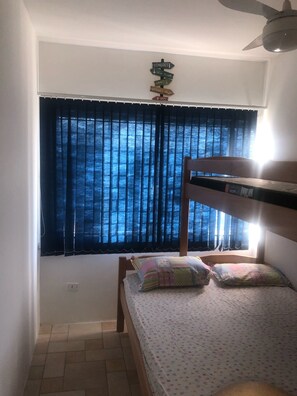 Cozy bedroom with a bunk bed, window, and ceiling fan.