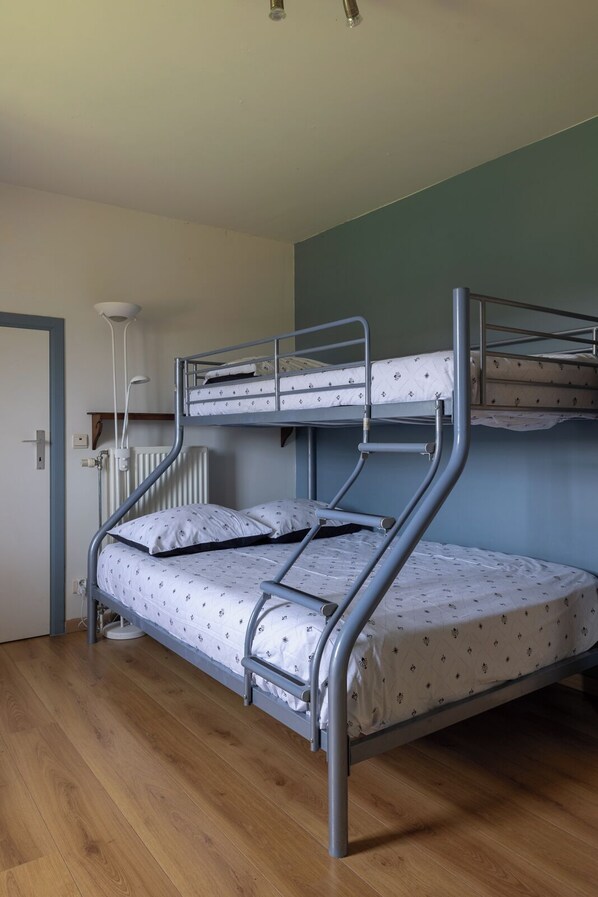 A bunk bed room with a wooden floor, a radiator, and a white lamp. - Villa De Ruiter / Waasmunster (Waasmunster)