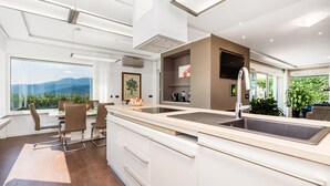 A modern kitchen with a large island, built-in appliances, and a view of the outdoors. - Gorgeous home in Rijeka (Rijeka)