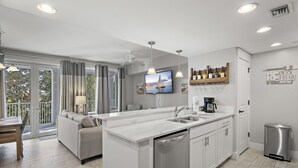 Una cocina moderna con una isla central, lavavajillas integrado y cafetera.