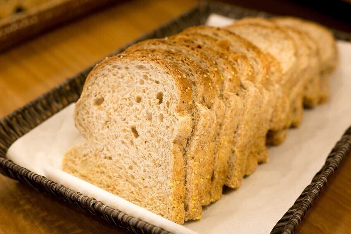 Une miche de pain tranché sur une assiette blanche.