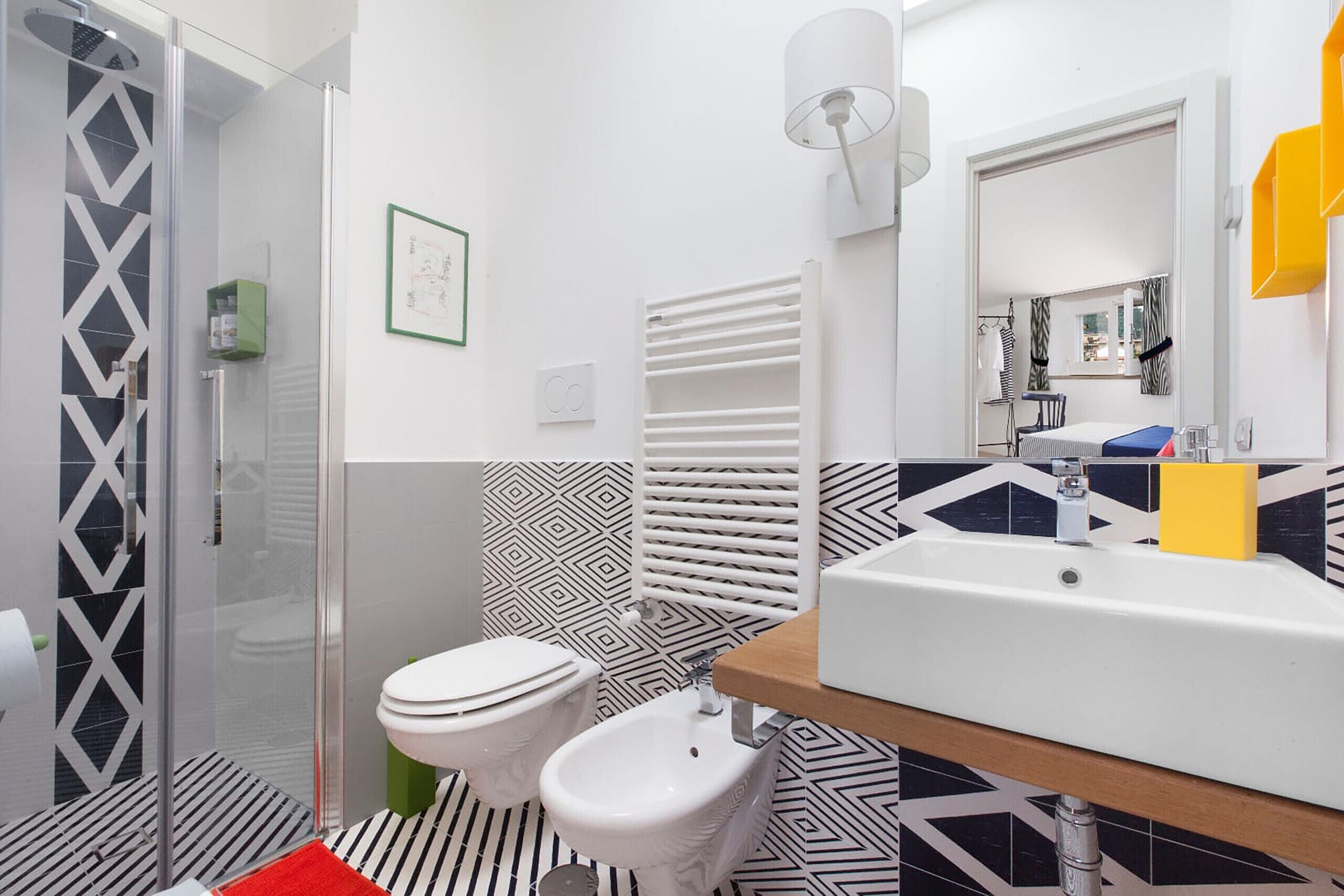 A modern bathroom with a shower, toilet, bidet, and a large sink.