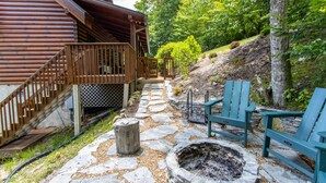 A wooden cabin with a stone pathway leading to outdoor seating.