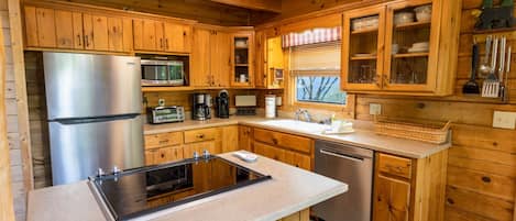 Una cocina moderna con armarios de madera, electrodomésticos de acero inoxidable y una isla central con asientos.