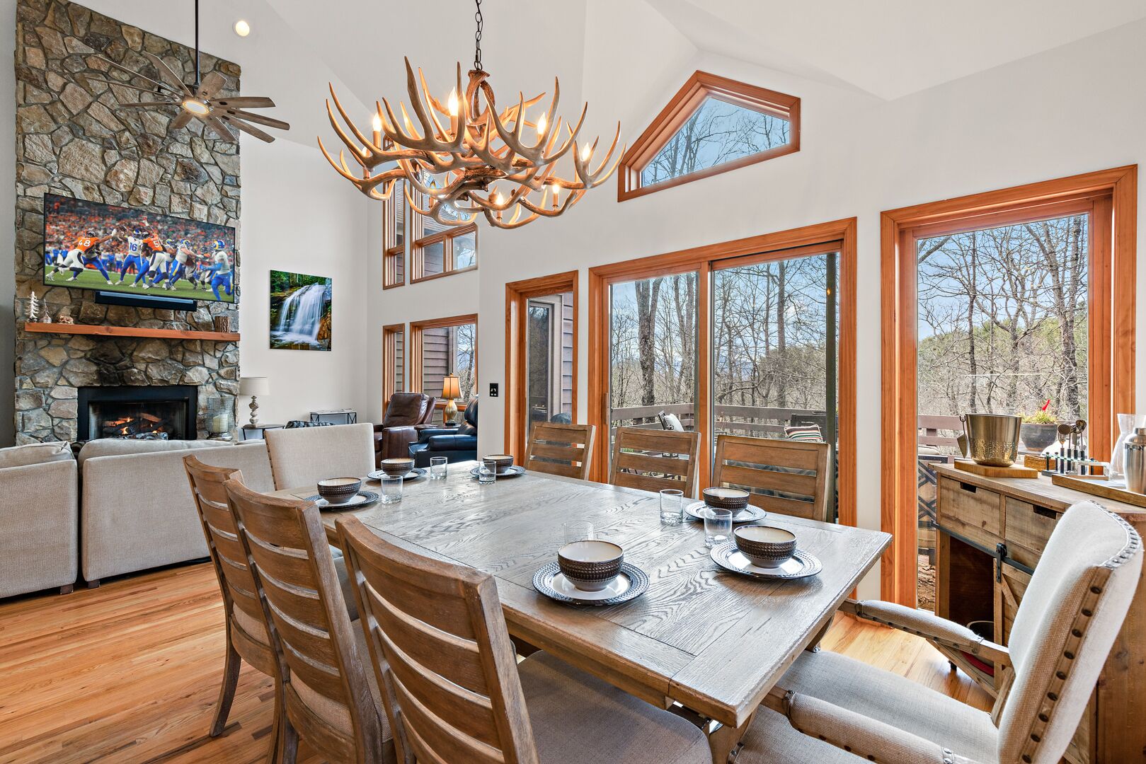 A spacious dining area with a large wooden table set for six, surrounded by wooden chairs.