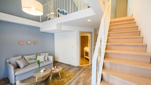 A modern living room with a sofa, coffee table, and a staircase.