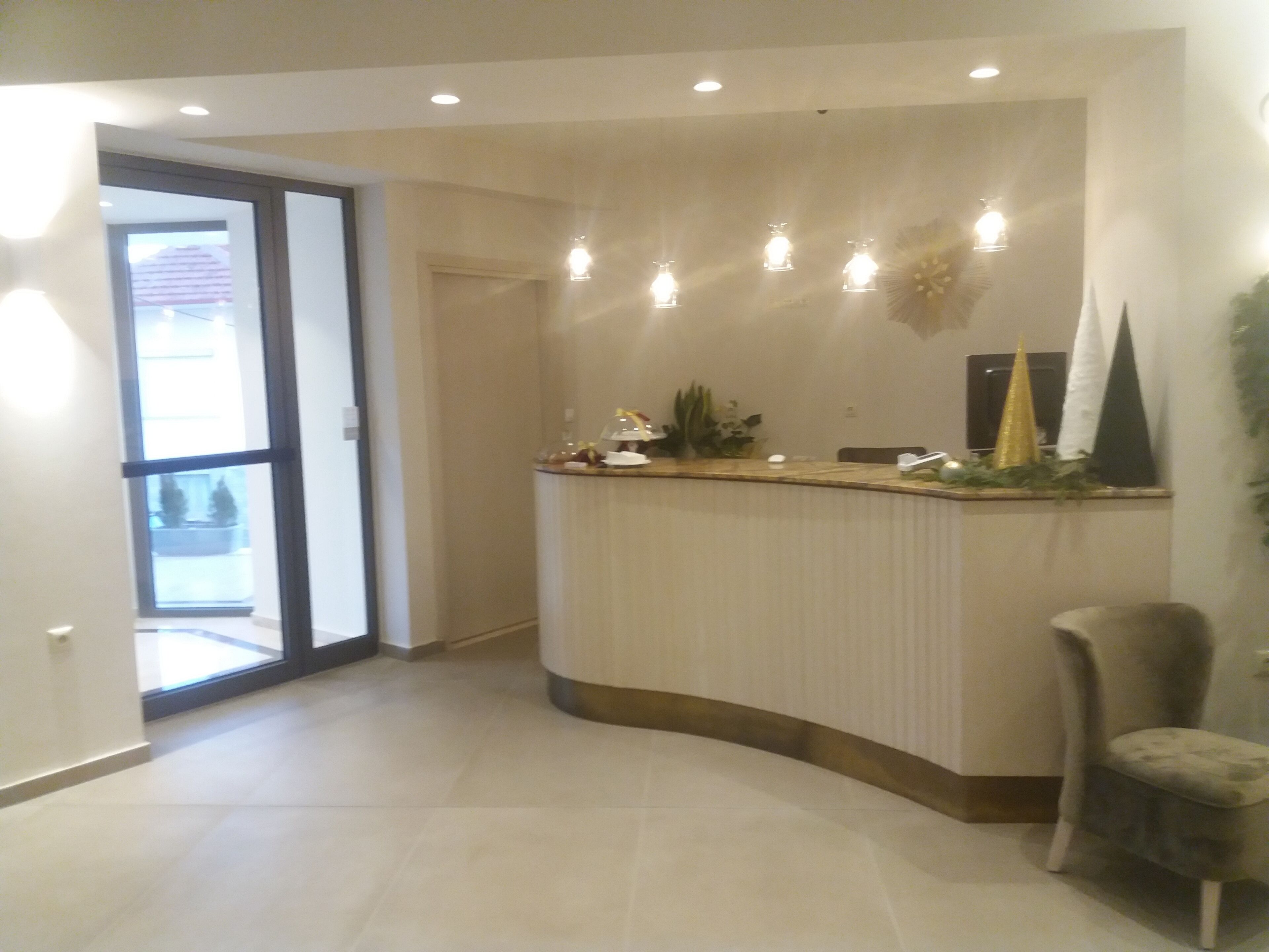 A reception area with a curved counter, a chair, and a door leading outside.