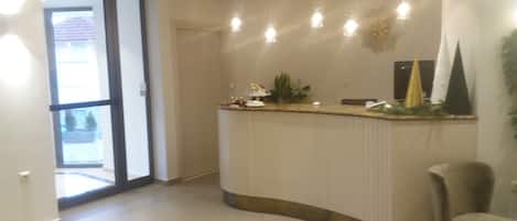 A reception area with a curved counter, a chair, and a door leading outside.