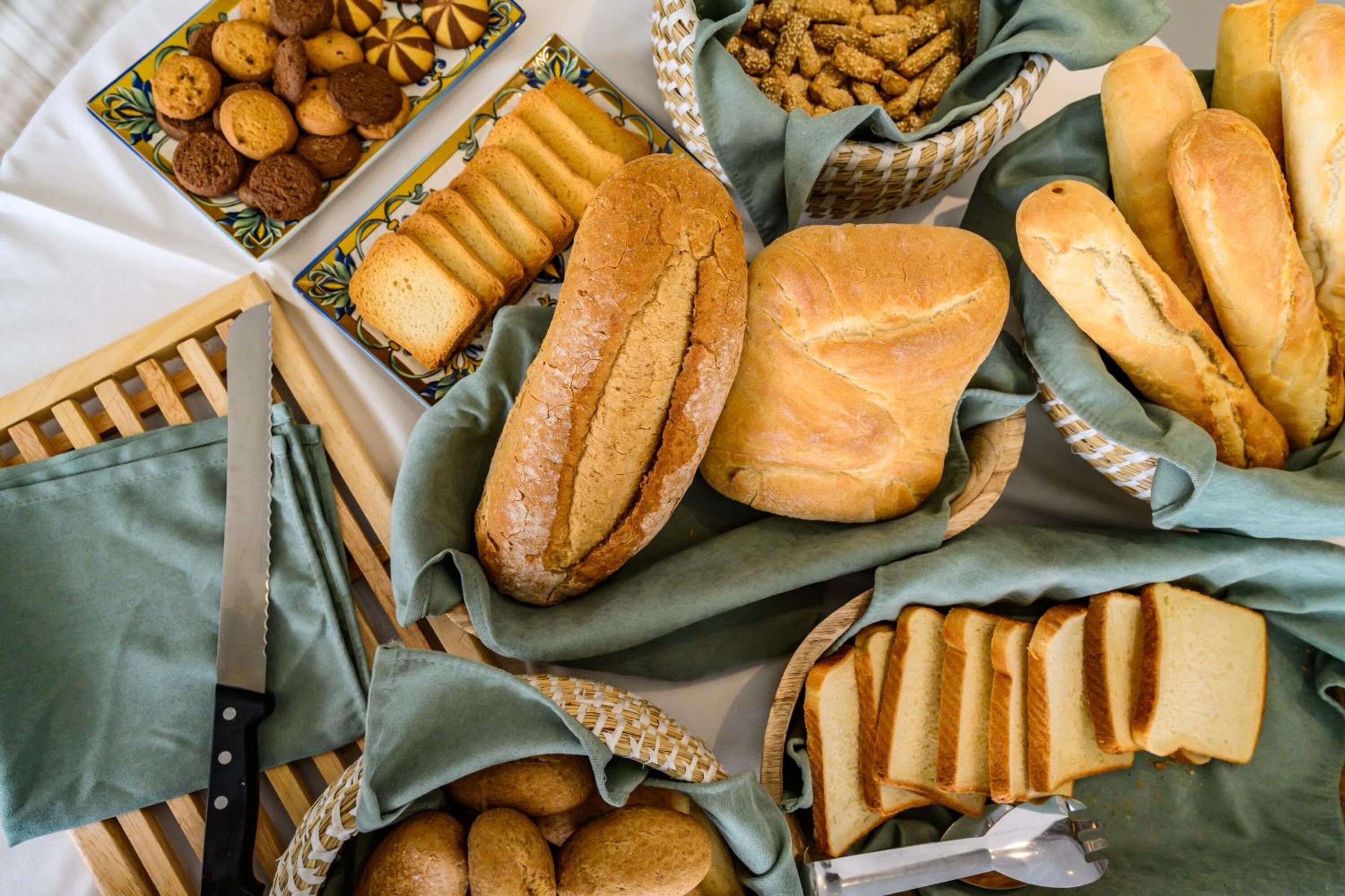 Diverse broden en gebak uitgestald op een tafel, met een mes en een vork.