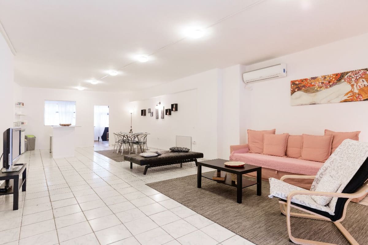 Un vaste espace de vie comprenant un canapé, une table basse et une table à manger avec des chaises.