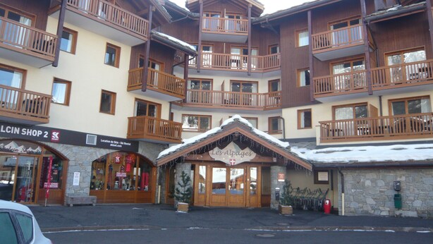 A multi-story hotel with balconies, a ski rental sign, and a shop named "Les Alpages". - Apartment in 4 * residence, Les Alpages de Val Cenis (Lanslevillard)