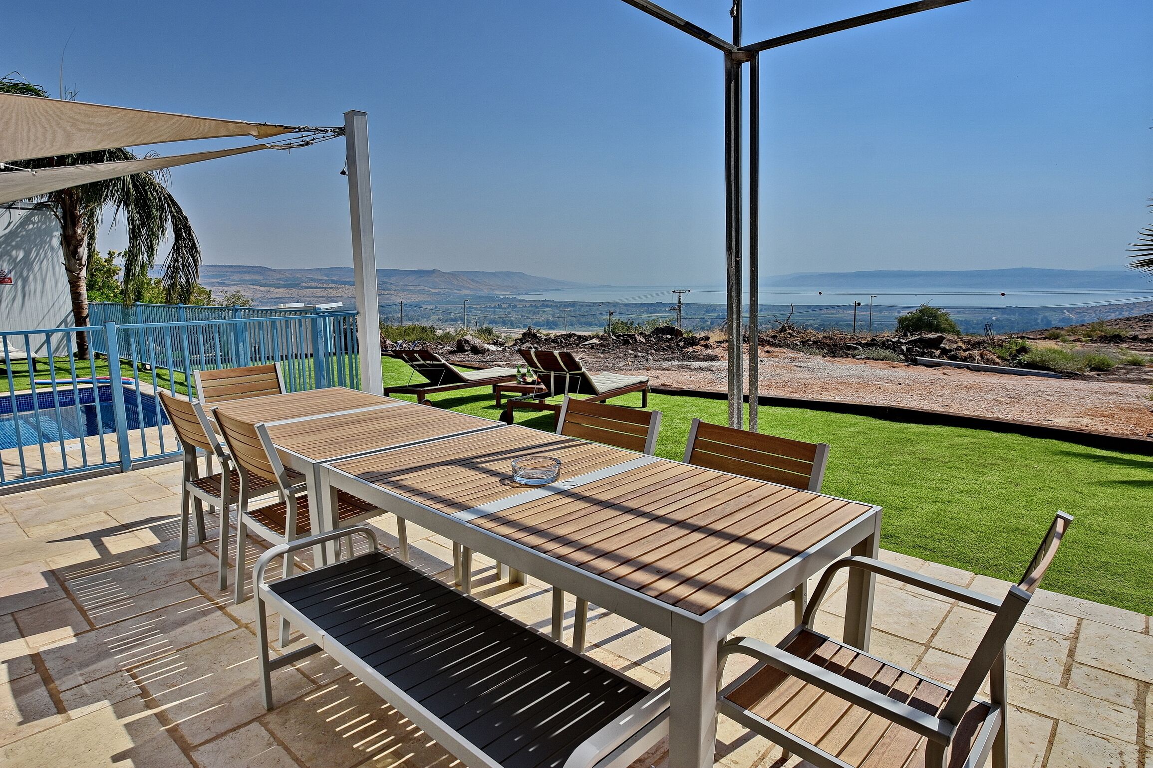 Un patio con piscina, mobiliario exterior y vistas al paisaje.