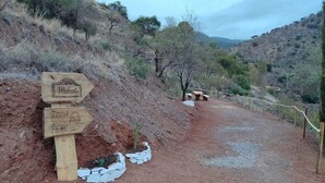 A dirt path leading to picnic tables and a sign indicating a picnic area.